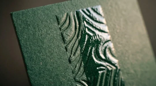 Détail macro de finitions d'impression sur papier haut de gamme montrant la texture et le relief